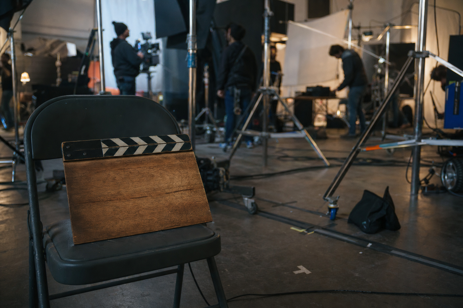Dietro le quinte di una produzione cinematografica con attrezzatura, luci e claque sul set